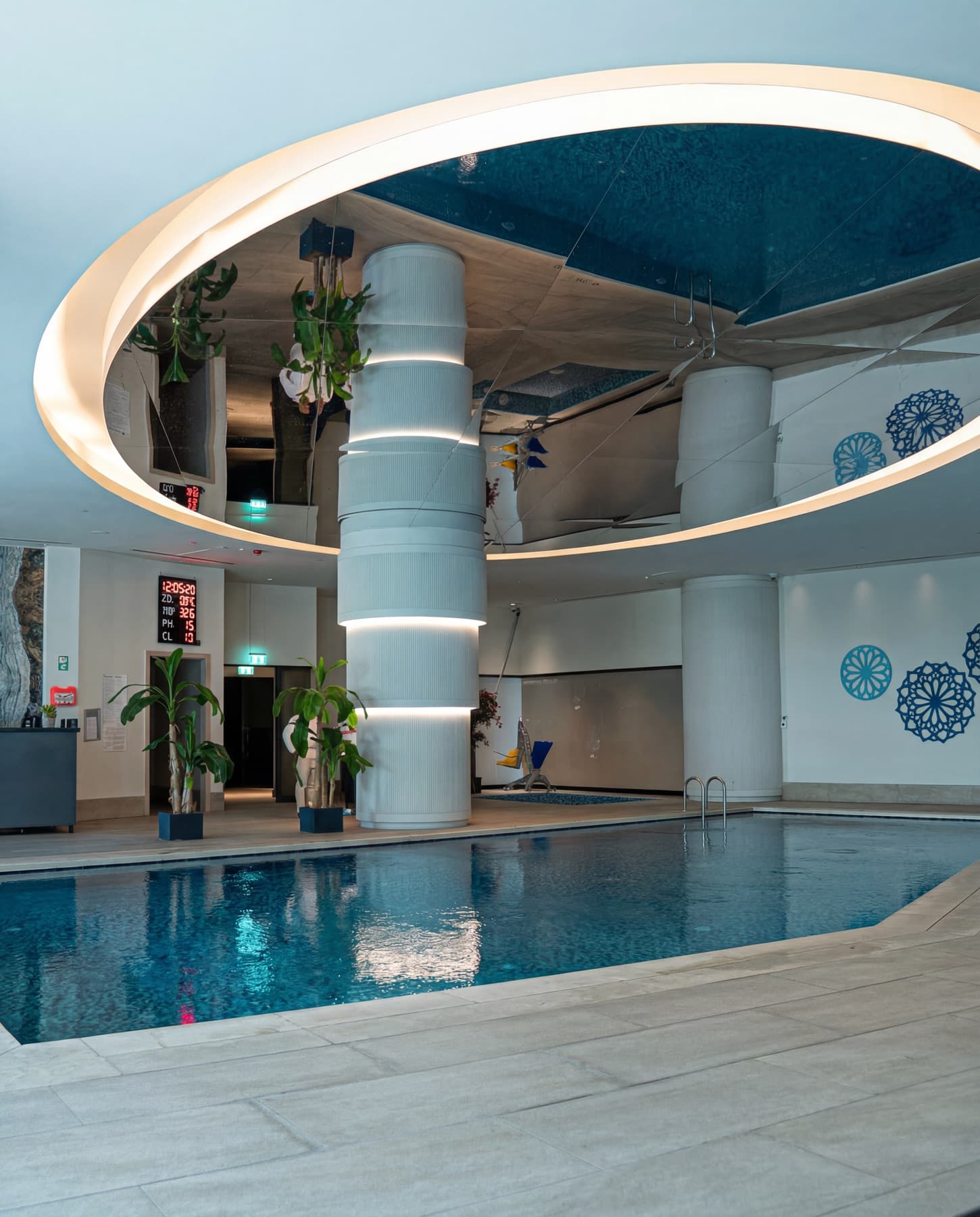 Navitas Spa kapalı yüzme havuzu — aynalı oval tavan ve turkuaz su